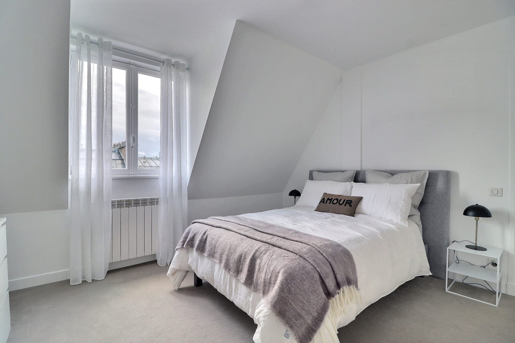 Chambre sous combles ouverte sur les toits de Paris, lumière de fenêtre conservée sans brûler le ciel