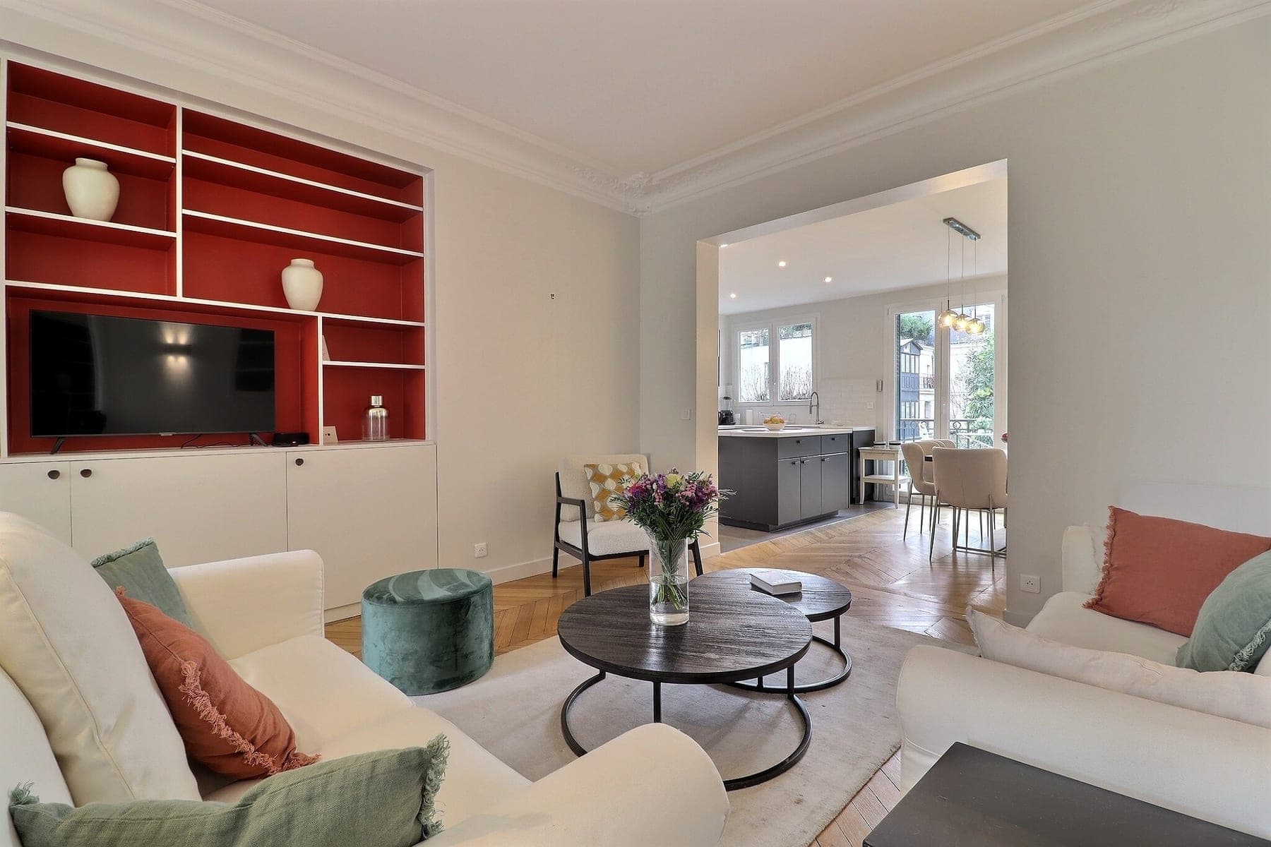 Séjour haussmannien parisien ouvert sur la cuisine : moulures, parquet à chevrons et verticales redressées